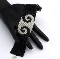 a black and white beaded bracelet with the letter g on it