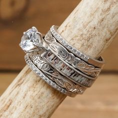 a stack of rings sitting on top of a piece of wood next to a wooden stick