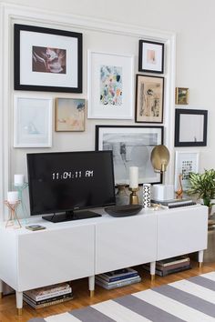 a white entertainment center with pictures on the wall