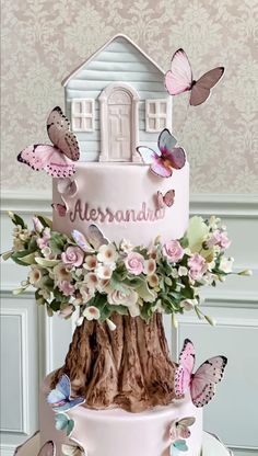 there is a pink cake with butterflies on it and the name alersanaud