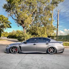 a silver car parked in front of a tree