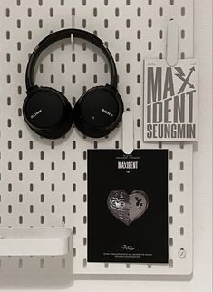 headphones are hanging on the wall next to a pair of magnets and a book