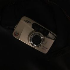 a silver camera sitting on top of a black bag