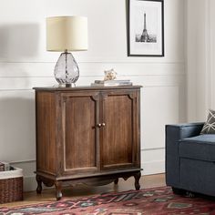 a living room with a blue couch and a wooden cabinet in front of a white wall