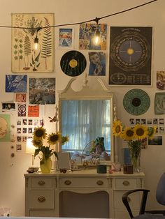 a white desk with sunflowers and pictures on the wall