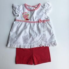 Sweet Outfit for Baby of Eyelet Shirt with Picnic Embroidery and Matching Red Shorts. Eyelet shirt with red and white gingham trim around collar, and below chest with a bow. Picnic embroidered as well as fruit and flowers, gingham print apple. Ruffle cap sleeves and along hem and draping. 1 button closure. Red shorts have elastic waist band. Size: 12 months Brand: Fisher Price Please view my shop! New items added often: https://www.etsy.com/shop/AutumnRoseArtVintage Fitted Gingham Sets For Spring, Casual Cotton Gingham Sets, Casual Gingham Cotton Sets, Red Cotton Sets, Embroidered Short Sleeve Sets For Spring, Summer Embroidered Short Sleeve Sets, Embroidered Short Sleeve Spring Sets, Embroidered Short Sleeve Summer Sets, Spring Embroidered Short Sleeve Sets