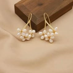 These floral pearl drop earrings are handmade with multiple real AAA quality freshwater pearls and are simply beautiful. The pearls have a smooth, natural white surface that is glowing, and the pearls are designed with a flower-like pattern that encases the pearl and adds a charming touch of beauty. The earrings are delicate, and the white pearls and floral design perfectly complement each other to form an exquisite piece of jewelry. The perfect statement piece for a bride or make them your go-t Wedding Pearl Earrings Dangle, Handmade Flower Pearl Earrings, Handmade Flower-shaped Pearl Earrings, Pearl Charm Drop Flower Earrings, Pearl Flower Drop Earrings With Pearl Charm, Flower Shaped Pearl Drop Earrings For Gift, Bride Earrings Pearl, Pearl Ball Earrings, Unique Pearl Earrings