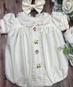 Pre-order handmade smocked romper. Takes from 4-6 weeks to ship. Thank you for your patience.  Thank you for supporting a small business.  Clothing Care Instructions Most items can be washed safely in cold water on delicate cycle and hung to dry. If the item that you are ordering has red or another bright color in it next to a white or other light color fabric please use a Shout color catcher for the first few washes to avoid bleeding. The reds are pre-washed but they are still red and will like Cream Fitted Bubble Romper With Ruffles, Fitted Cream Bubble Romper With Ruffles, Cute Cream Bubble Romper With Ruffles, Spring Cotton Bubble Romper With Smocked Cuffs, Cute Cotton Bubble Romper With Smocked Bodice, Spring White Bubble Romper With Smocked Back, White Bubble Romper With Smocked Back For Spring, White Cotton Bubble Romper With Smocked Back, Cute Fitted Bubble Romper For Baptism