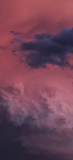 an airplane is flying in the sky with pink and blue clouds behind it at sunset