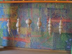 several wooden ornaments hanging from a colorful wall