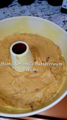 a white bowl filled with hummus sitting on top of a counter next to a bottle of ketchup