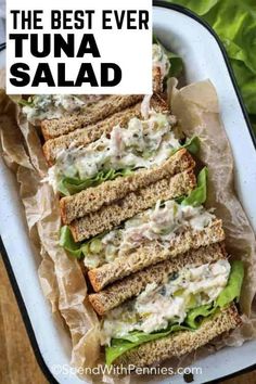 tuna salad sandwich with lettuce and mayonnaise on toasted bread in a white dish