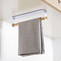 two towels hanging from a towel rack in a bathroom with white walls and wooden beams