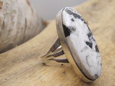 If you're looking for an unadorned, contemporary style statement ring set with a beautiful piece of white buffalo then this ring is for you.  Long, oval White Buffalo cab is 1 3/8" in length, and nice mix of black and white material.  Contemporary bezel setting with triple split shank.  Size 8. Hallmarked RP.   Your interest is appreciated and many thanks for supporting our small business.      WE NOT SHIP INTERNATIONALLY. Returns:  Carefully review the description of the item and the pictures.  If you have any questions, please ask before ordering.  We do not, in general, issue refunds, but may be considered on case-by-case basis.  Refund will not be issued until the item has been received and will be issued minus shipping or other costs as deemed necessary by the seller.  If a refund is Unique White Rings With Polished Finish, Unique White Cabochon Rings, Adjustable White Oval Rings, White Oval Adjustable Rings, Unique White Oval Cabochon Rings, White Oval Ring With Large Stone, White Buffalo, Split Shank, Style Statement