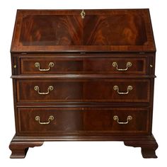 a wooden chest with three drawers and brass handles on the bottom drawer, against a white background