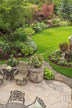 an outdoor patio area with chairs, tables and flowers on the lawn in front of it