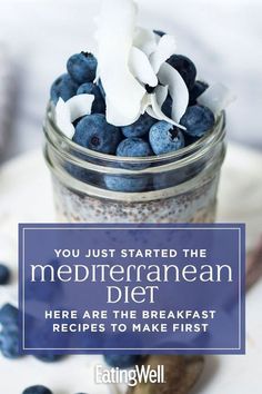 a jar filled with blueberries and granola on top of a table