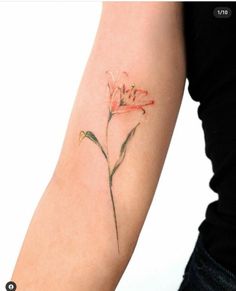 a woman's arm with a flower tattoo on the left side of her arm