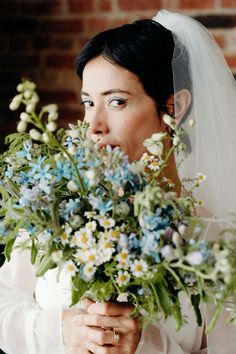 a woman holding a bouquet of flowers in her hands