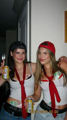 two young women dressed in costumes holding cans and posing for the camera with their arms around each other