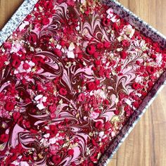 a close up of a cake with red flowers on it and chocolate frosting in the middle