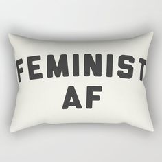 a white rectangular pillow with the words feminist af printed in black on it's front