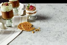 three desserts are sitting on a table with white towels and napkins next to them