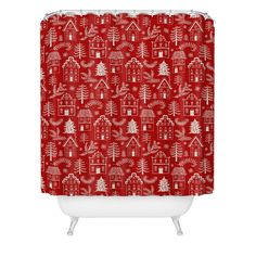 a red shower curtain with white christmas trees and houses on the front, against a white background