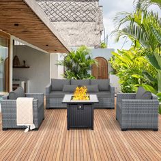 an outdoor living area with furniture and fire pit in the middle of wooden flooring