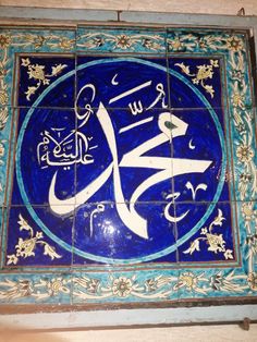 an arabic calligraphy on a tile wall in a building with blue and white tiles