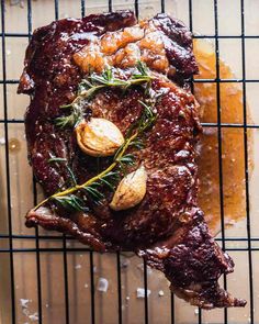 a piece of meat sitting on top of a cooling rack covered in sauce and garnish