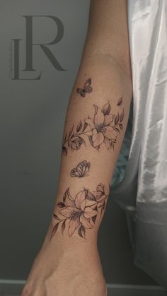 a woman's arm with flowers and butterflies on it