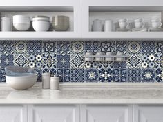 blue and white tile backsplash in a kitchen with dishes on the counter top