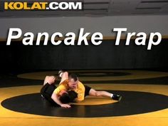 two men in yellow shirts are wrestling on a black mat with the words kolat com pancake trap