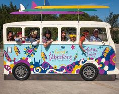 a group of people riding on the back of a bus with surfboards above their heads