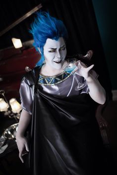 a woman with blue hair is dressed in costume