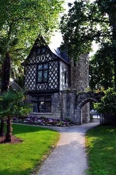 an old house is shown in the middle of some trees and grass, with a path leading to it