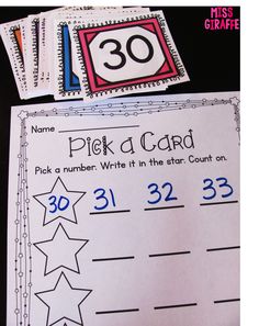 two sheets of paper with numbers and stars on them, next to some cards that say pick a card