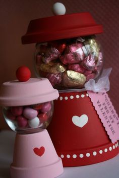 a candy dispenser filled with pink and red candies next to a valentine's day card