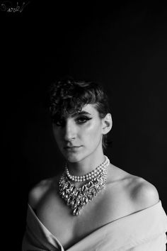 black and white photograph of a woman in a dress with pearls on her neck wearing a necklace