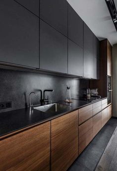 a kitchen with black counter tops and wooden cabinets