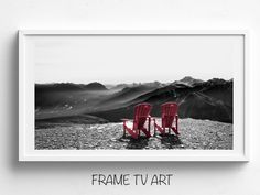 two red chairs sitting on top of a mountain