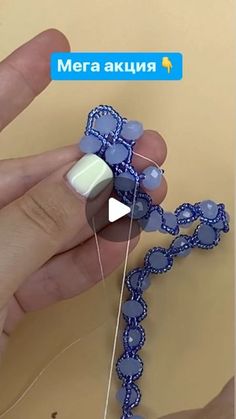 someone is making something out of beads and thread with the help of their thumbnails