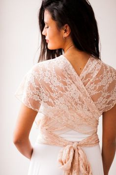 the back of a woman's head wearing a white dress with lace on it