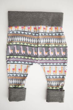 a baby's pants with llamas and triangles on the bottom, sitting on a white surface