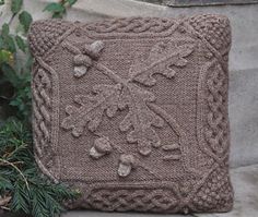 a knitted pillow sitting on top of a stone wall