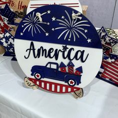 an american patriotic sign is displayed on a table with other patriotic signs and decorations in the background