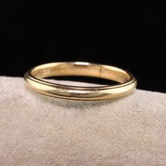 a gold wedding ring sitting on top of a white cloth