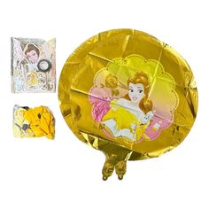 an image of a golden foil cake with princesses on it and other items in the background