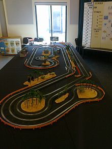 a toy track set up on a table in front of a projector screen